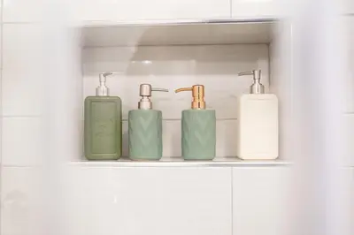 four green and white bottles on a shelf in a bathroom at Pnoé d Athéna in Athens