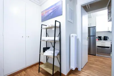 a kitchen with white walls and a shelf with towels at Glamorous Apt in Kolonaki in Athens