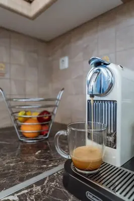 a mixer sitting on a counter with a cup of coffee at Anavissos Seaview Holiday Home in Anavissos