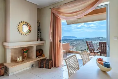a living room with a fireplace and a table and chairs at Anavissos Seaview Holiday Home in Anavissos