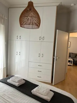 a bedroom with a large white cabinet and two towels at Cityspace Apartment, Athens in Athens