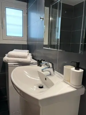 a bathroom with a white sink and a mirror at Cityspace Apartment, Athens in Athens