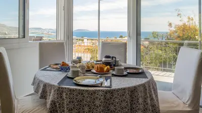 a breakfast table with a view of the ocean at Bunny island- seaview house, private garden , Lagonisi, Attika riviera by Comfortbnb in Lagonissi