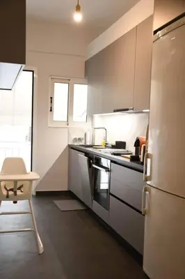 a kitchen with a refrigerator and a table in it at central Athens apartment near Kallimarmaro hosted by vasiliki in Athens