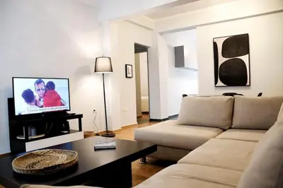 a living room with a couch and a flat screen tv at central Athens apartment near Kallimarmaro hosted by vasiliki in Athens