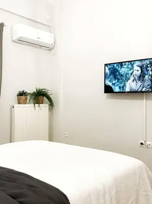 a bedroom with a bed and a tv on the wall at central Athens apartment near Kallimarmaro hosted by vasiliki in Athens