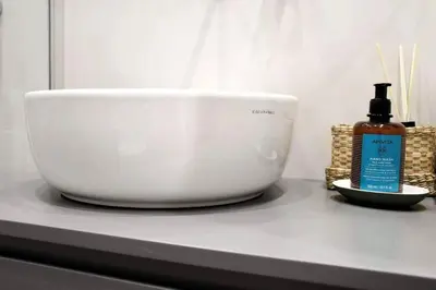 a white bowl and a bottle of mouth wash on a counter at central Athens apartment near Kallimarmaro hosted by vasiliki in Athens