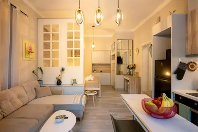 a living room and kitchen with a couch and a table at Peacock's Apartments in Piraeus