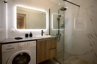 a bathroom with a washing machine and a sink at Peacock's Apartments in Piraeus