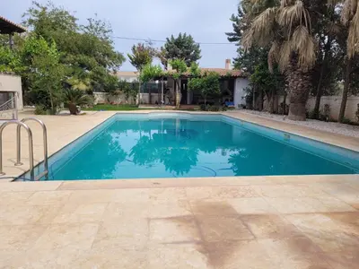 a swimming pool with blue water in a yard at Riviera Paradiso in Aghia Marina