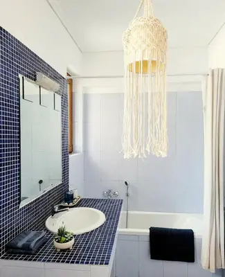 a bathroom with a sink and a chandelier at Riviera Paradiso in Aghia Marina