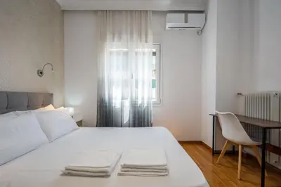 a bedroom with a white bed and a desk and a window at “Athens Cosmos” Apartment in Neos Kosmos in Athens