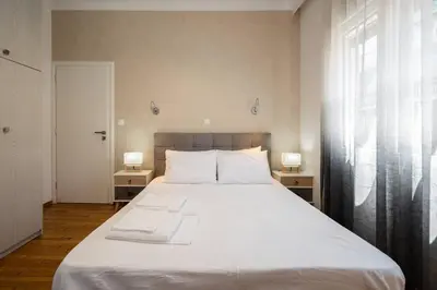 a bedroom with a large white bed with two lamps at “Athens Cosmos” Apartment in Neos Kosmos in Athens