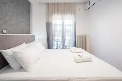 a bedroom with a white bed with white pillows at “Athens Cosmos” Apartment in Neos Kosmos in Athens