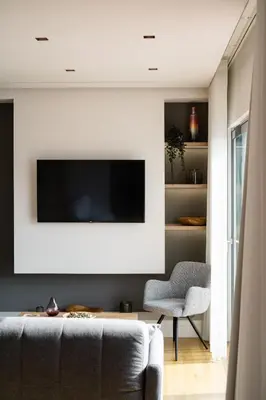 a living room with a couch and a tv on a wall at Acropolis Luxury Penthouses with Majestic Views in Athens
