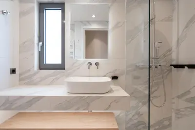 a white bathroom with a sink and a shower at Acropolis Luxury Penthouses with Majestic Views in Athens