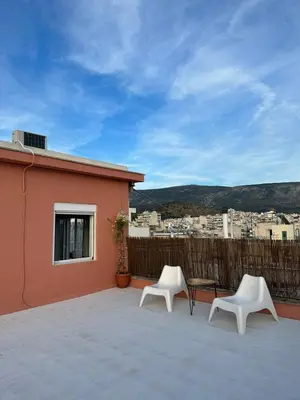 two white chairs and a table on a balcony at Eagle's Nest Acropolis View in Athens