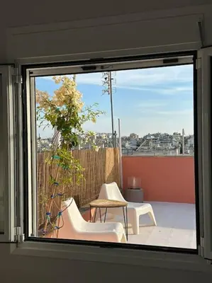 a window with two chairs and a table on a balcony at Eagle's Nest Acropolis View in Athens