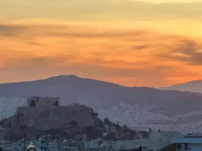 a hill with a castle on top of it at sunset at Eagle's Nest Acropolis View in Athens