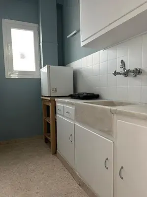 a kitchen with white cabinets and a sink and a window at Eagle's Nest Acropolis View in Athens