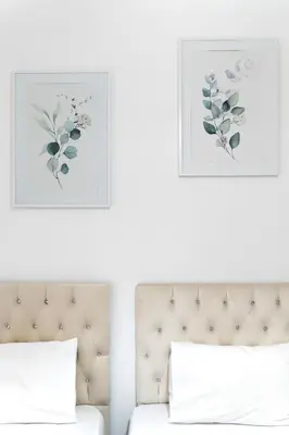 a bedroom with a bed with two pictures on the wall at ILIADA Luxury Apartment in Porto Rafti