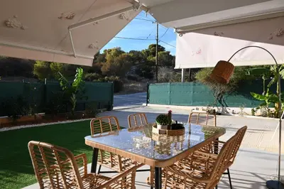 a table and chairs under an umbrella on a patio at ILIADA Luxury Apartment in Porto Rafti