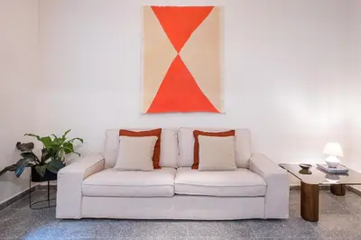 a white couch in a living room with a painting at Eden in Athens