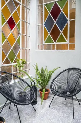 two chairs in front of a window with stained glass at Eden in Athens