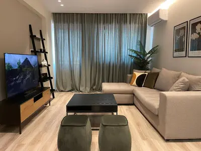 a living room with a couch and a flat screen tv at Modern & Spacious 3BR apartment in Athens