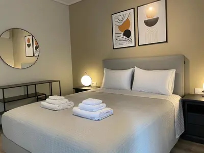 a bedroom with a white bed with towels on it at Modern & Spacious 3BR apartment in Athens