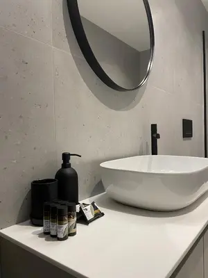 a bathroom with a white sink and a mirror at Modern & Spacious 3BR apartment in Athens