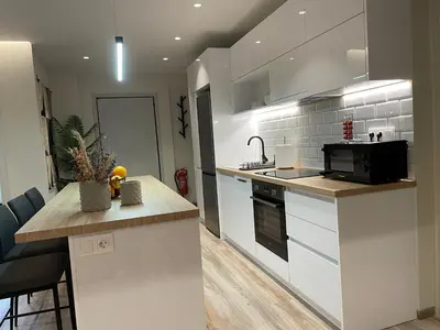a kitchen with white cabinets and a counter top at Modern & Spacious 3BR apartment in Athens