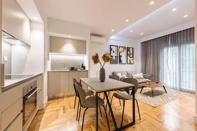 a kitchen and living room with a table and chairs at Phaedrus Living: Executive Flat Kolonaki in Athens