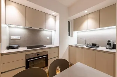 a kitchen with wooden cabinets and a table and chairs at Phaedrus Living: Executive Flat Kolonaki in Athens