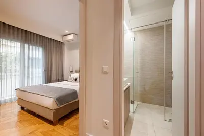 a bedroom with a bed and a walk in shower at Phaedrus Living: Executive Flat Kolonaki in Athens