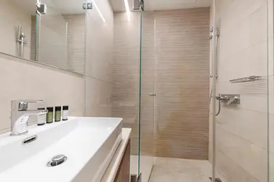 a bathroom with a sink and a glass shower at Phaedrus Living: Executive Flat Kolonaki in Athens