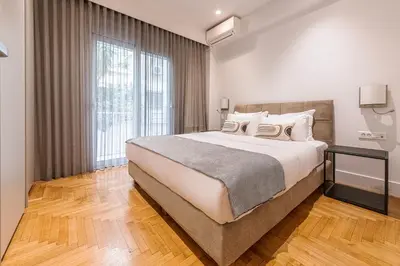 a bedroom with a large bed and a large window at Phaedrus Living: Executive Flat Kolonaki in Athens