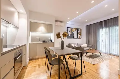 a kitchen and living room with a table and chairs at Phaedrus Living: Executive Flat Kolonaki in Athens