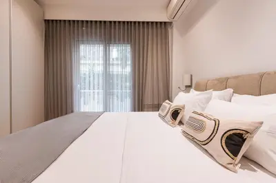 a large white bed in a room with a window at Phaedrus Living: Executive Flat Kolonaki in Athens