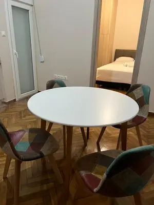 a white table and chairs in a room with a bed at Evita's cozy apartment in Athens