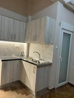 a kitchen with wooden cabinets and a sink at Evita's cozy apartment in Athens
