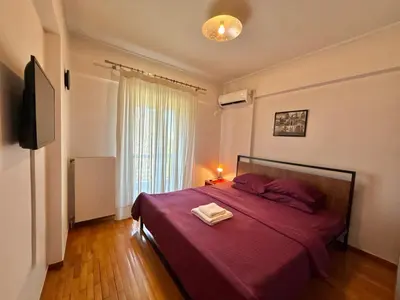 a bedroom with a large bed with a red blanket at Central Glyfada 2BR Apartment in Athens