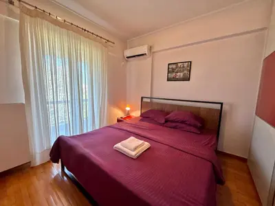 a bedroom with a purple bed with a towel on it at Central Glyfada 2BR Apartment in Athens