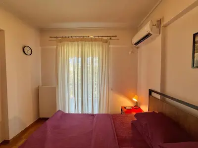 a bedroom with a purple bed and a window at Central Glyfada 2BR Apartment in Athens