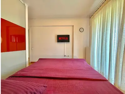 a bedroom with a bed with a red bedspread at Central Glyfada 2BR Apartment in Athens
