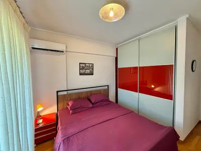 a bedroom with a bed with a purple blanket at Central Glyfada 2BR Apartment in Athens