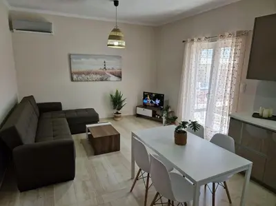 a living room with a white table and a couch at Casa al Mare Anavissos in Anavissos