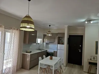 a kitchen with a table and a white table and chairs at Casa al Mare Anavissos in Anavissos