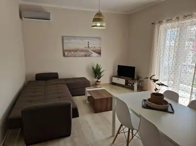 a living room with a couch and a table at Casa al Mare Anavissos in Anavissos