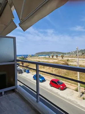 a balcony with a red car parked on a road at Casa al Mare Anavissos in Anavissos